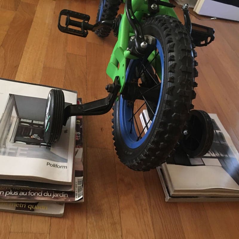 Bicycle in the house. Magazines or books under the training wheels. Inventive way to keep kids active.
