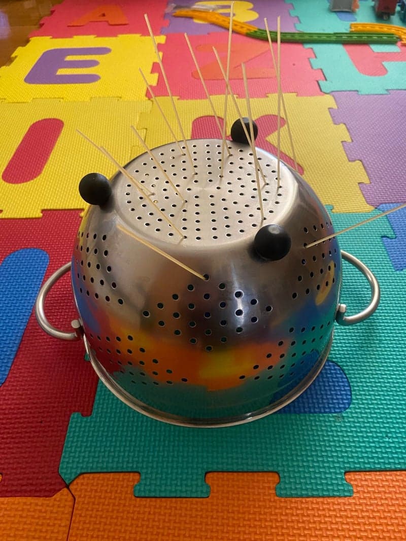 Educational play for preschoolers with spaghetti and colander. Fine motor skills.